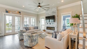 A spacious living room with a fireplace, comfortable seating, and a view of the outside.