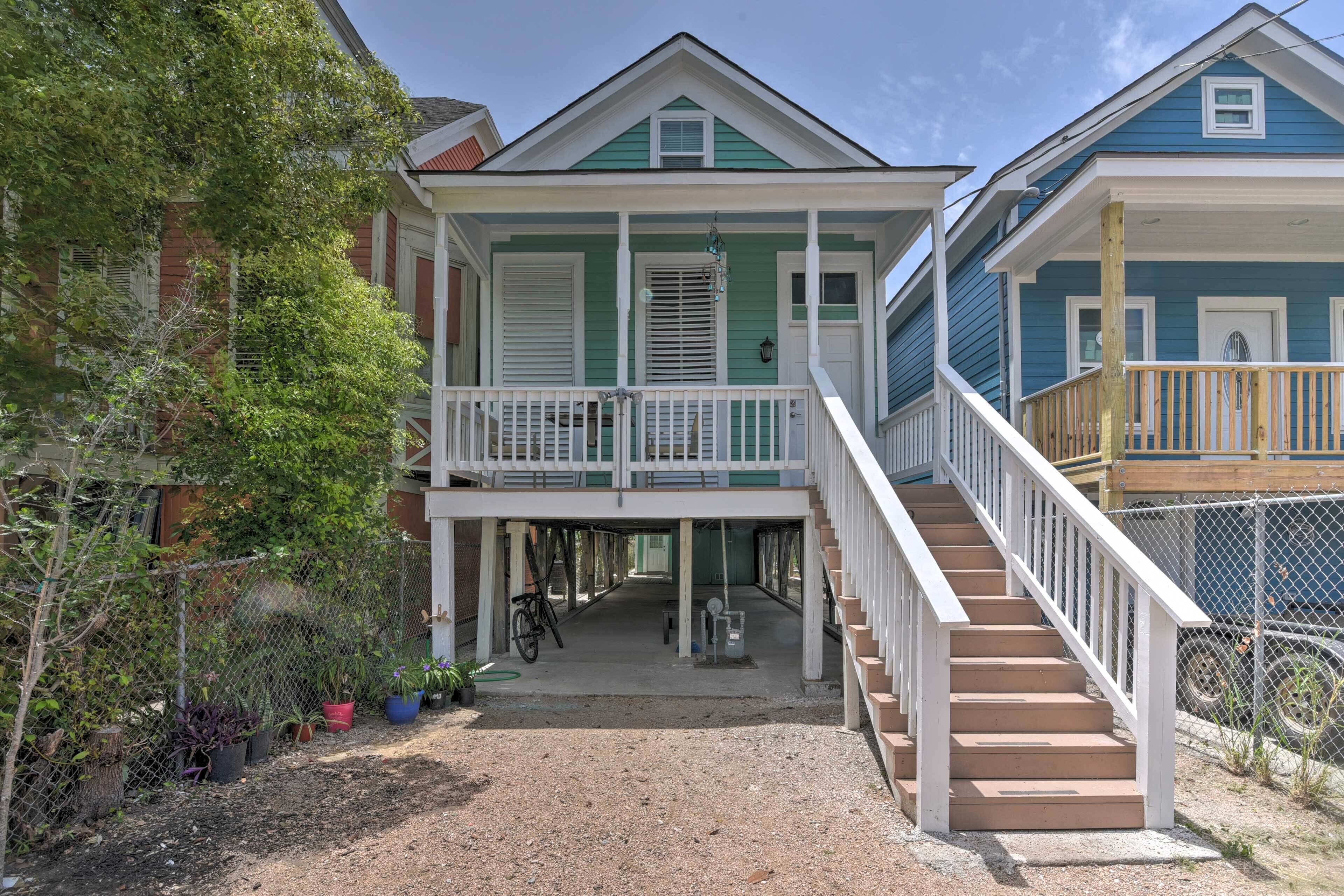 A two-story house with a porch, a staircase, and a fenced yard.
