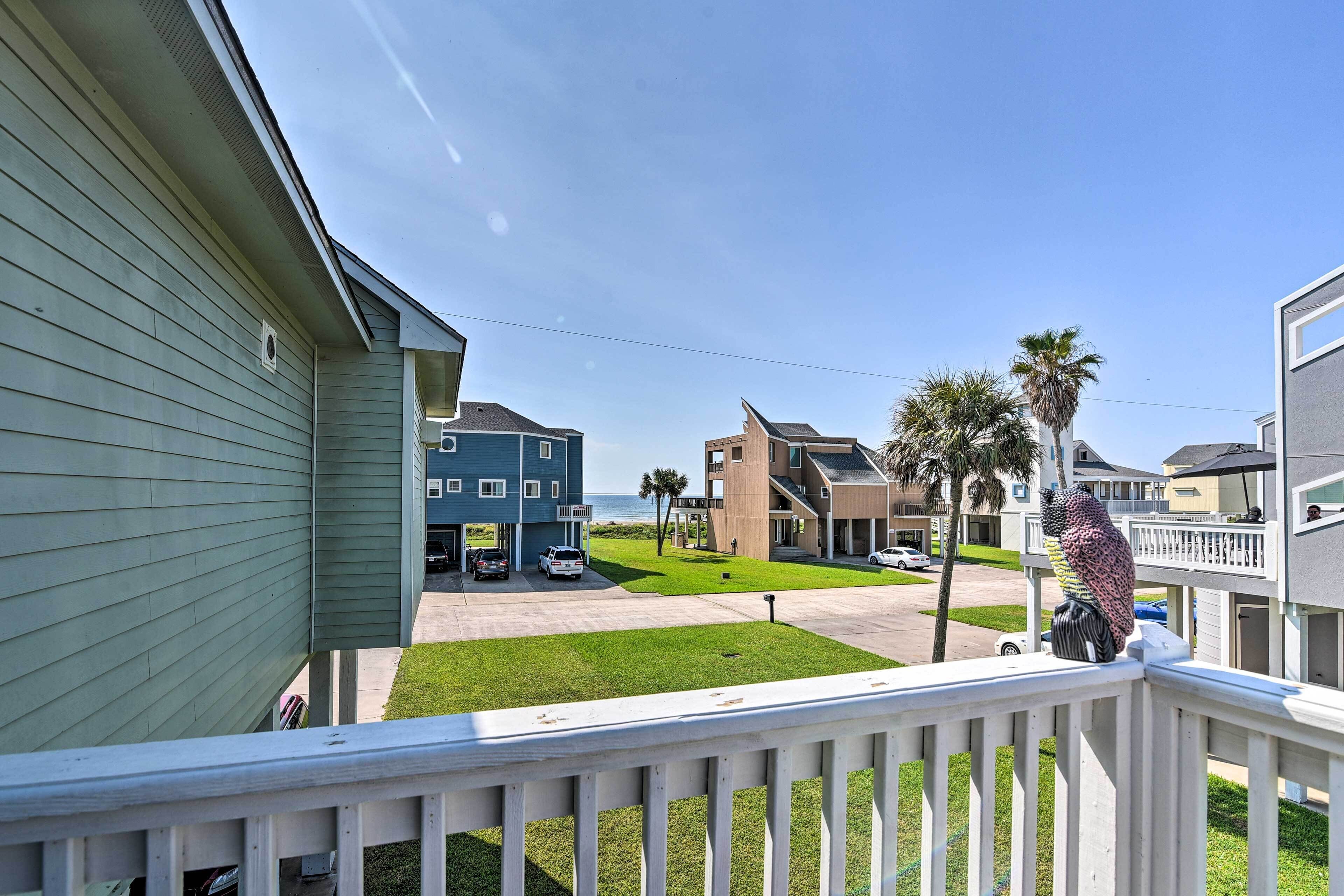 A residential area with houses, a lawn, and a view of the ocean.