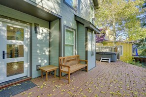 A wooden bench and table on a brick patio with a door and windows. - Not Available for Rental via Evolve (Park City)