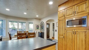 A kitchen with wooden cabinets, a granite countertop, and a built-in microwave.