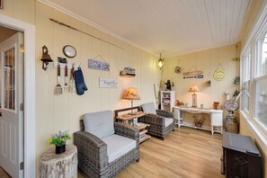 A cozy room with wicker furniture, a wooden table, and various wall decorations. - Solon Springs Getaway w/ Dock & Kayaks! (Solon Springs)