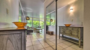 A modern kitchen with a large window, a wooden cabinet, and a countertop with a bowl.