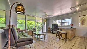 A spacious living area with a sofa, a table, and a bar area with stools.