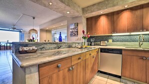 Una cocina moderna con armarios de madera, encimera de mármol y lavavajillas.