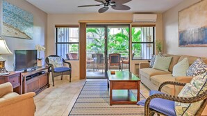 A living room with a television, sofa, chairs, and a coffee table.