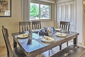 A dining table set with plates, cups, and napkins, with a window and blinds in the background. - Stunning Home w/ Private Oasis - 1 ½ Mile to Strip (Las Vegas)