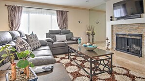 Una sala de estar moderna con un sofá gris, una mesa de centro y una chimenea.
