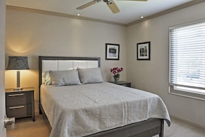 A bedroom with a bed, nightstands, a lamp, framed pictures, and a window with blinds. - Stunning Home w/ Private Oasis - 1 ½ Mile to Strip (Las Vegas)