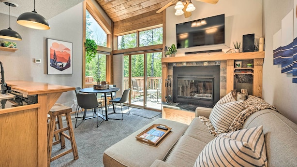 A cozy living area with a fireplace, a TV, and a dining area with a table and chairs. - Ski-in/ski-out Lutsen Retreat w/ Pool Access! (Lutsen)