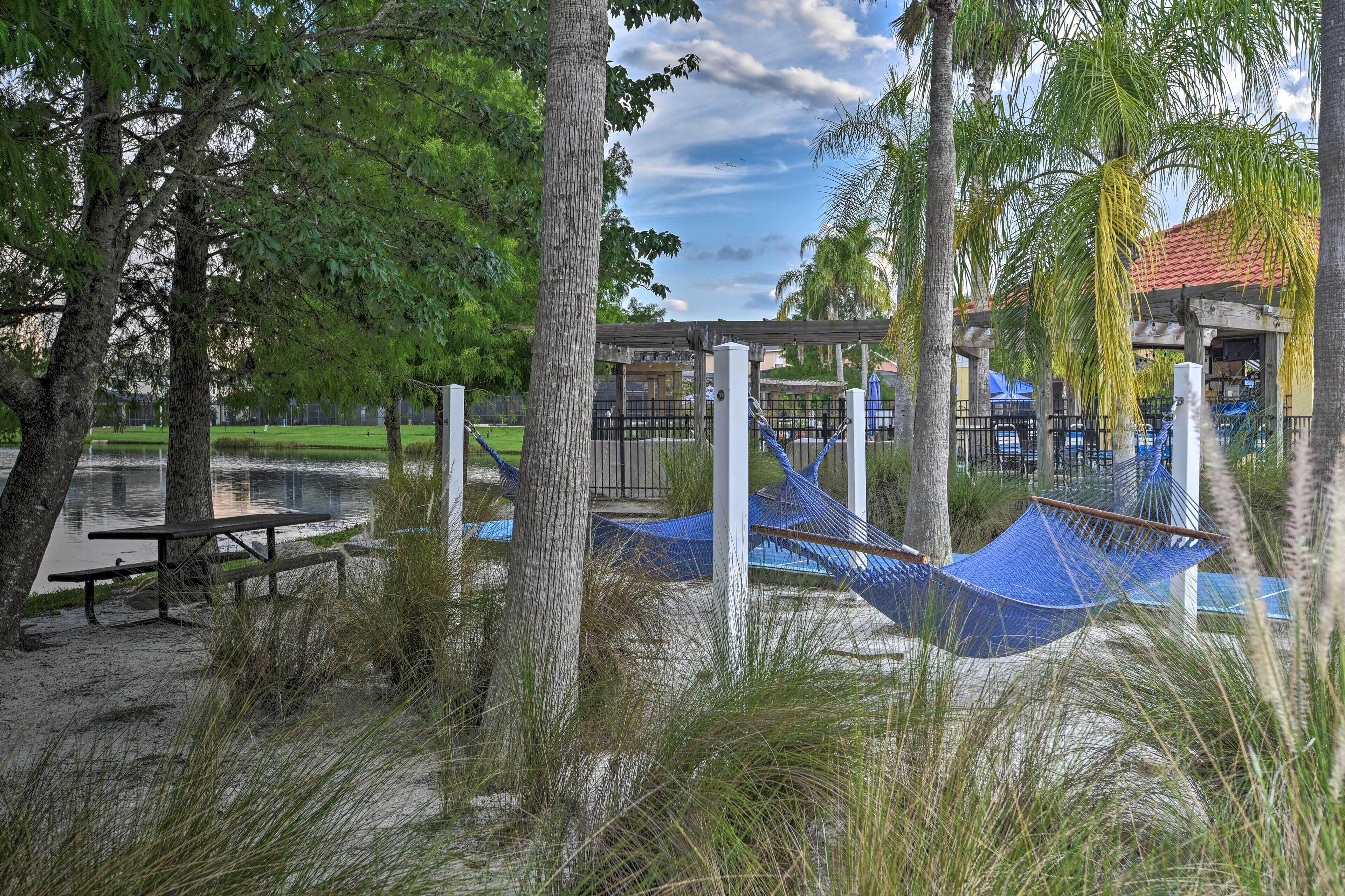 A park with a picnic table, hammocks, and a playground area.