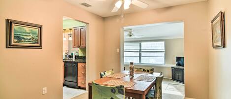 A dining area with a wooden table, chairs, and a ceiling fan.