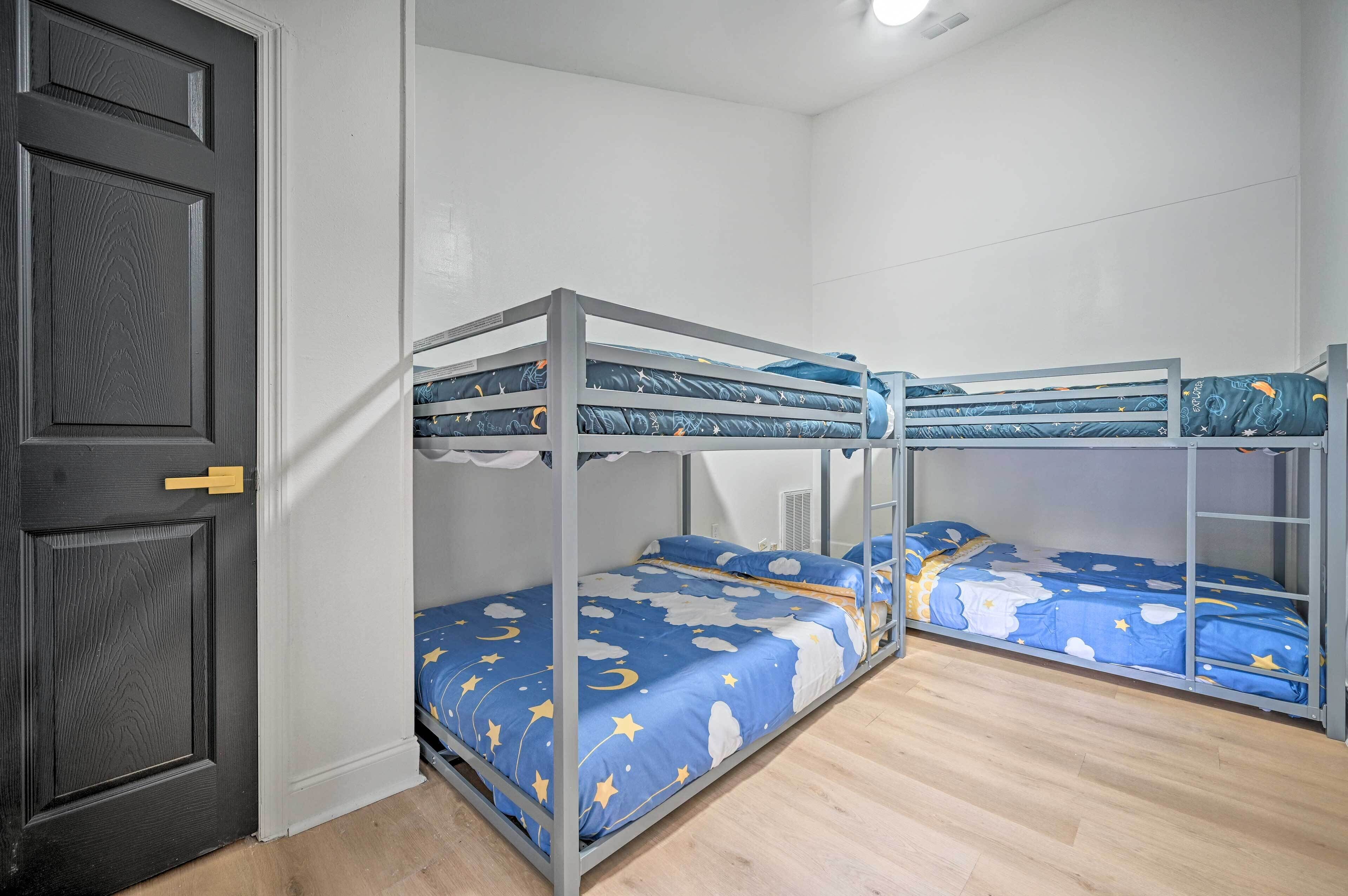 Ein Zimmer mit Etagenbetten, einer Tür und einer weißen Wand.