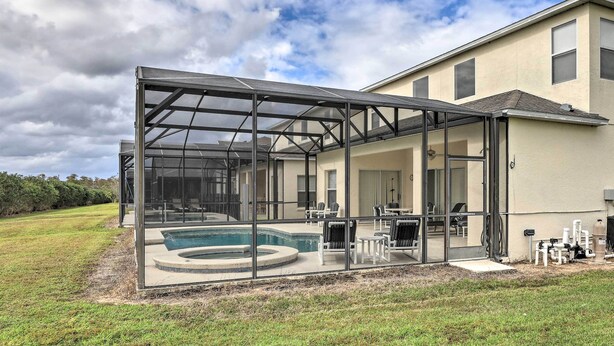 Ein Haus mit einem überdachten Pool und einer Außenlounge.