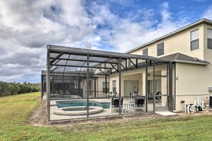 A house with a glass-enclosed swimming pool and outdoor seating area.