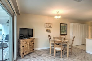 A dining area with a table and chairs, a television on a wooden cabinet, and a ceiling light fixture. - Waterfront Marco Island Retreat w/ Shared Docks (Marco Island)
