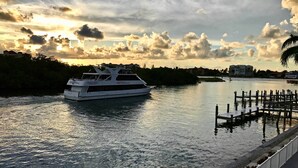 A white yacht docked at a marina with a dock and a pedestrian walkway.