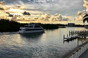 A white yacht docked at a marina with a dock and a pedestrian walkway. - Waterfront Marco Island Retreat w/ Shared Docks (Marco Island)