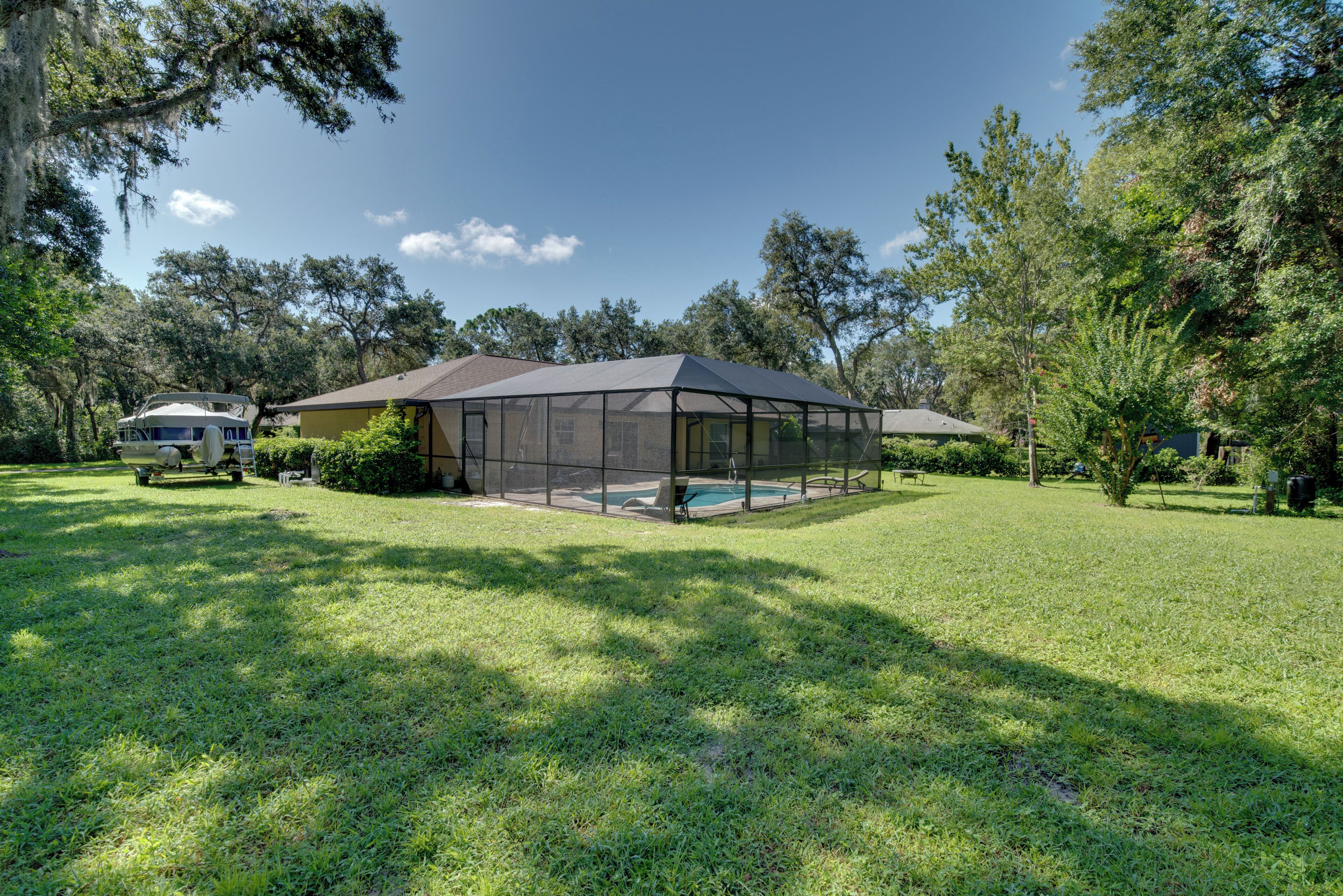 A house with a screened porch and a swimming pool.