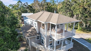 A multi-story house with a balcony, a covered porch, and a deck. - Decks, Docks & Kayaks: Waterfront Homosassa Gem (Homosassa)