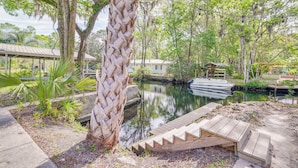 A serene outdoor area with a wooden deck, a small pond, and a covered structure. - Decks, Docks & Kayaks: Waterfront Homosassa Gem (Homosassa)