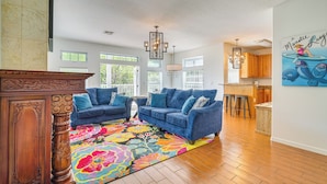 A spacious living room with a large floral rug, two blue sofas, and a wooden coffee table. - Decks, Docks & Kayaks: Waterfront Homosassa Gem (Homosassa)