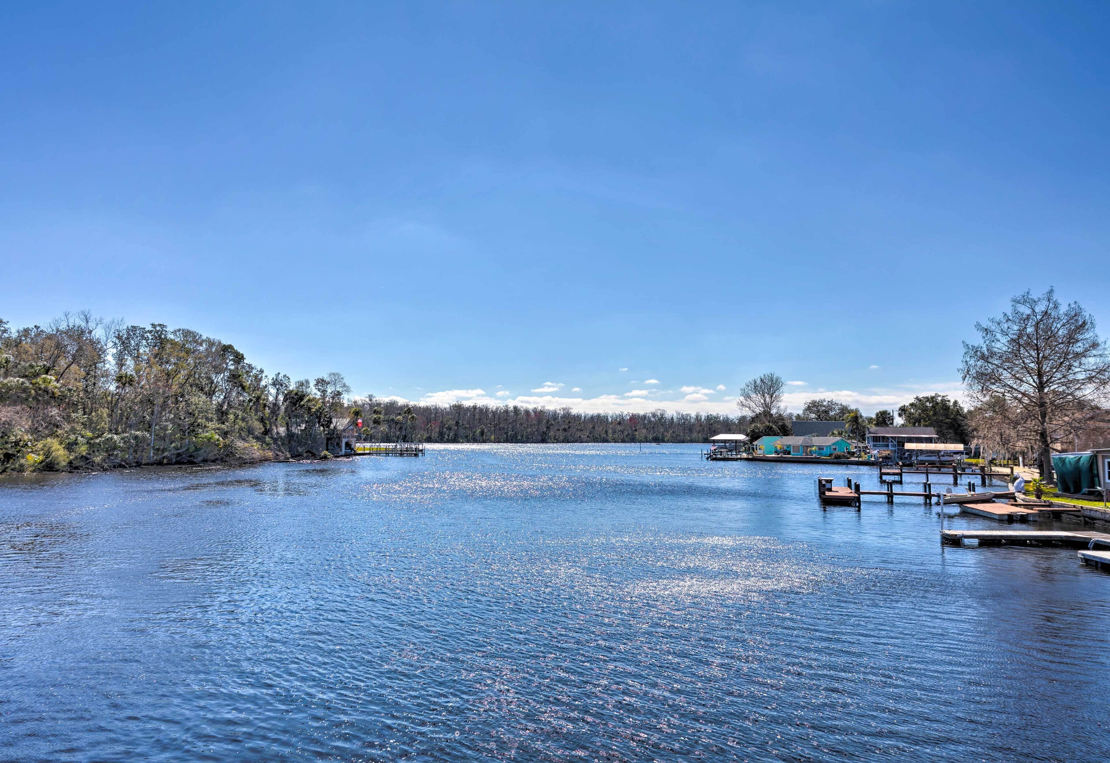 A calm lake with docks and a row of houses in the background.