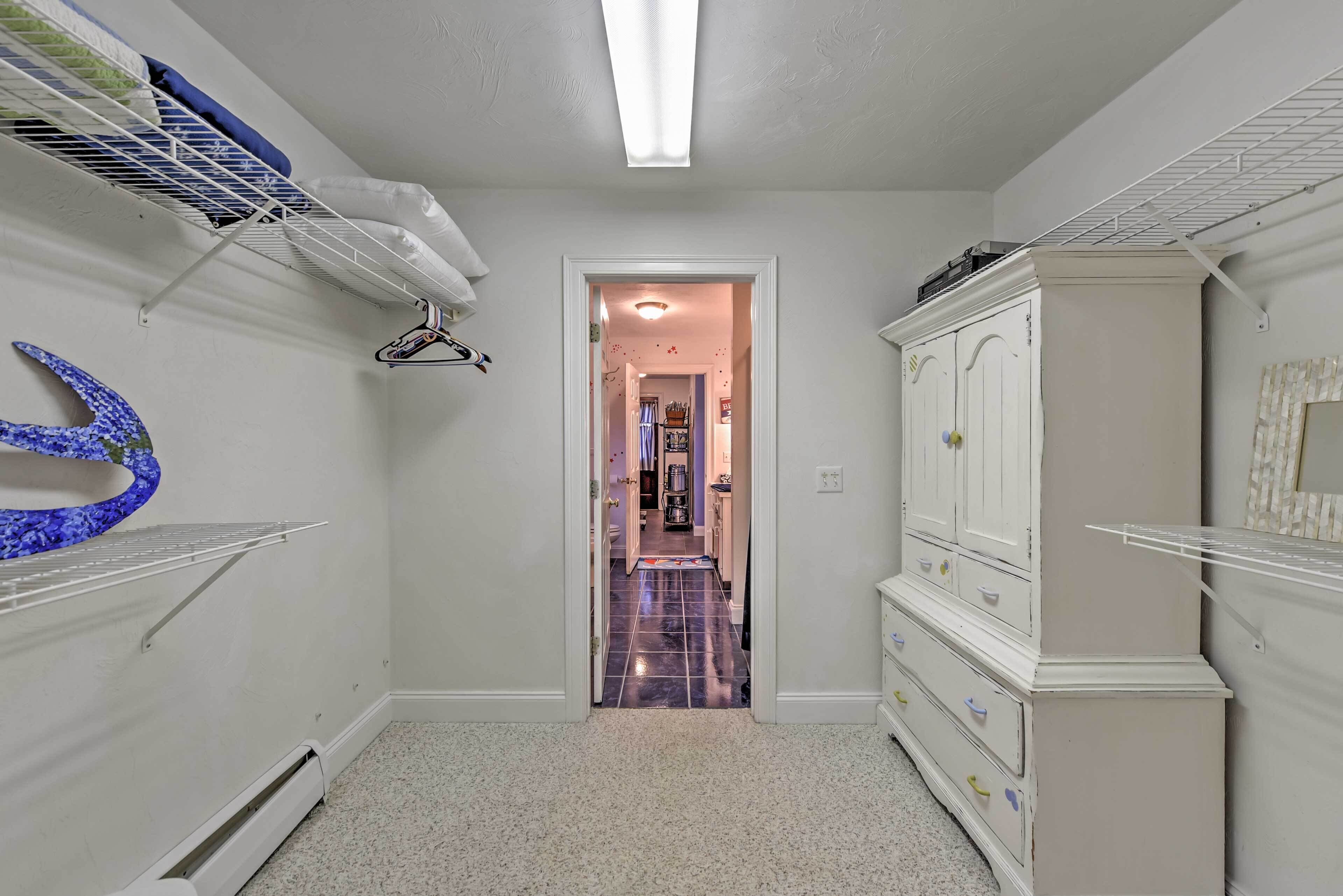 A narrow hallway with a white wardrobe, a radiator, and a door leading to another room.
