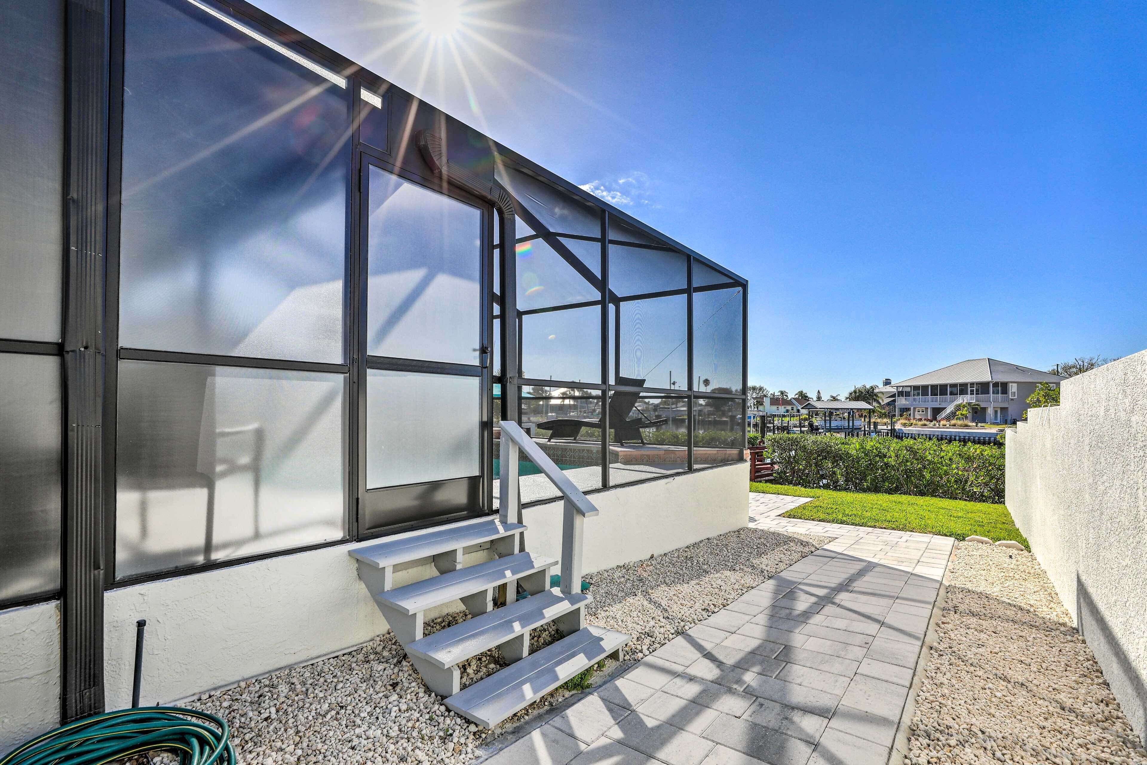 Un edificio moderno con grandes ventanales, una escalera de concreto y un patio empedrado.