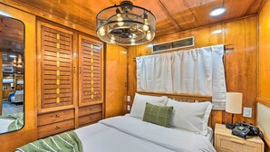 Ein Schlafzimmer mit Holzwänden, einem großen Bett, einem Nachttisch, einem Telefon und einem Spiegel.