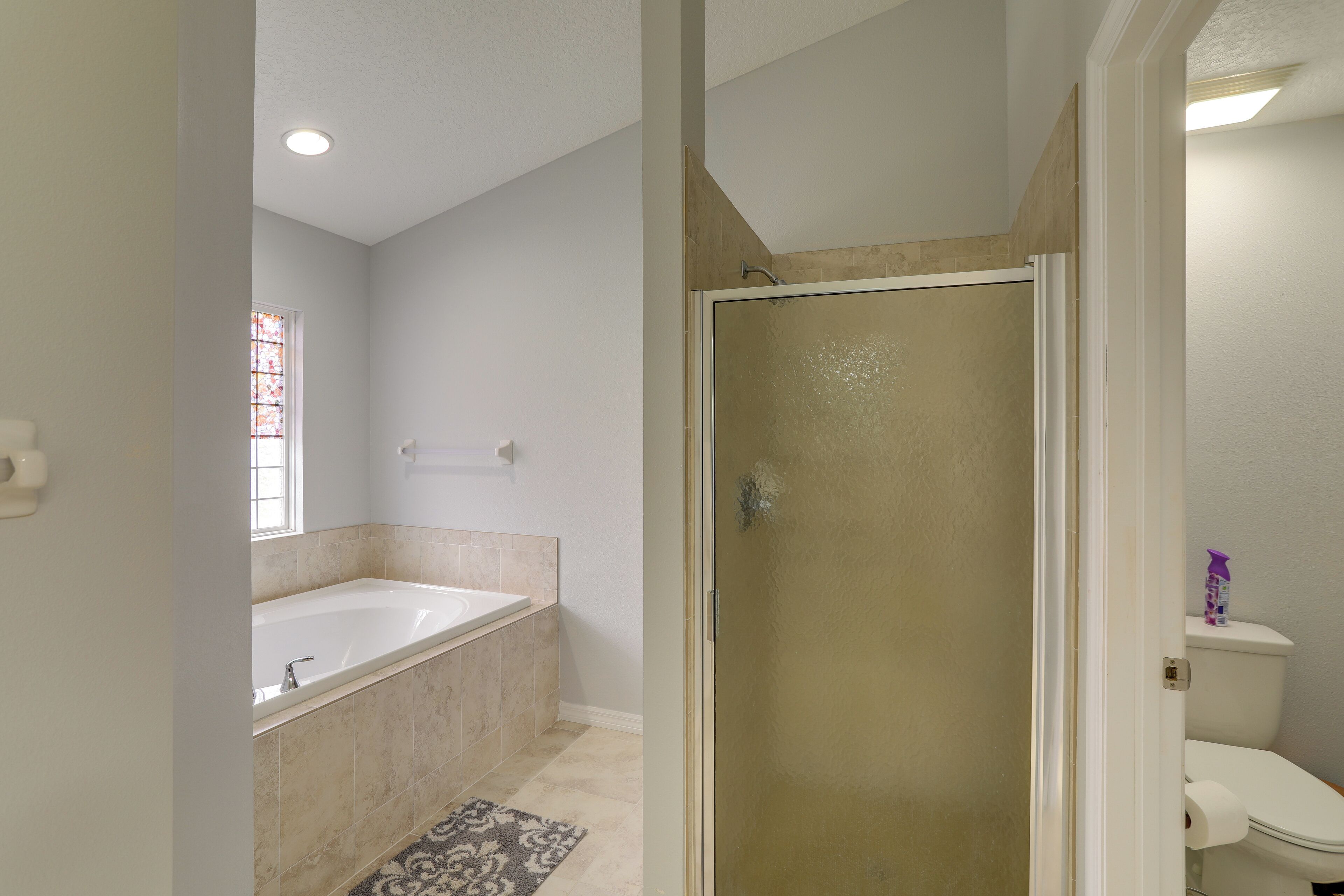 Un baño con bañera, cabina de ducha y retrete.