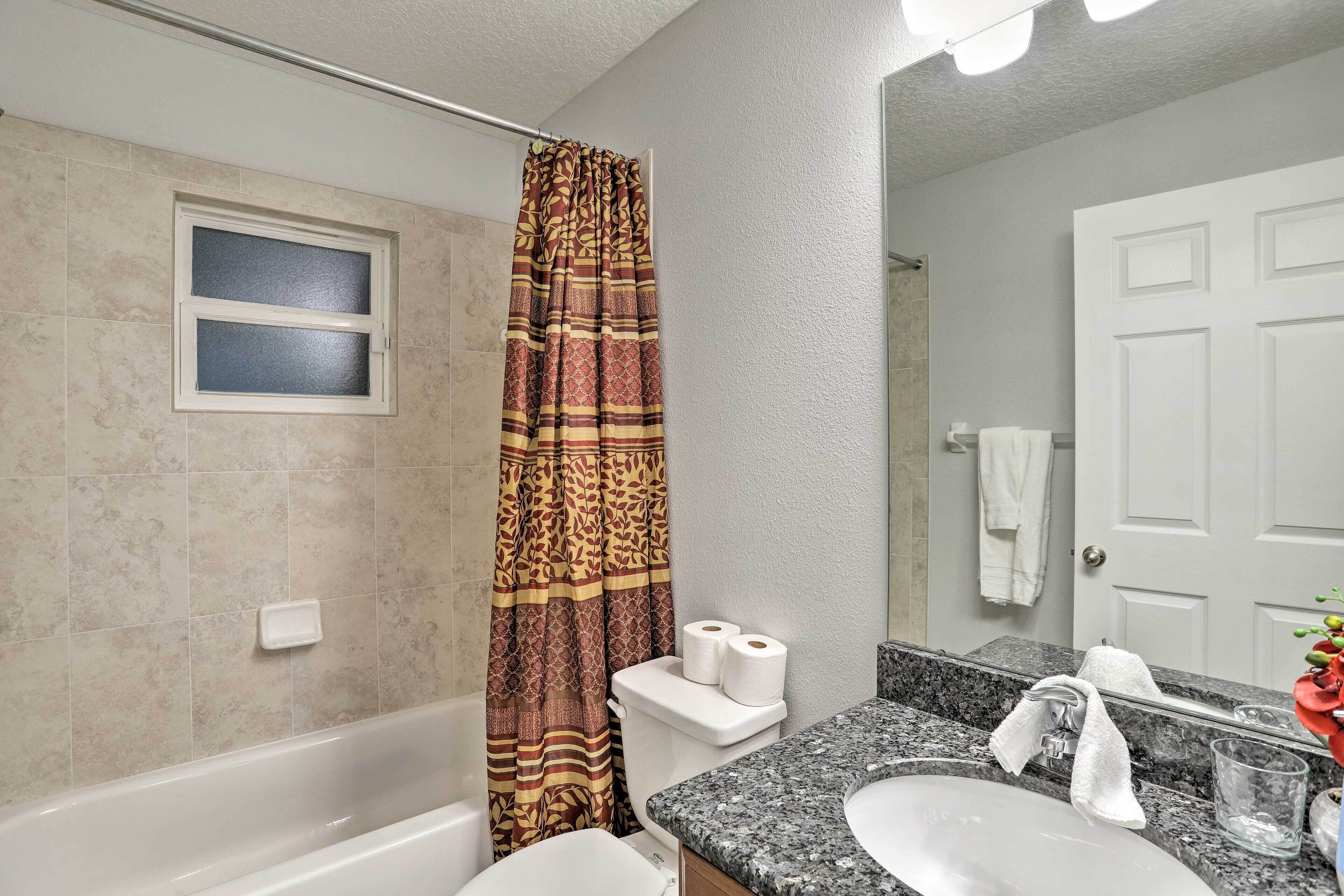 A bathroom with a bathtub, toilet, and sink.