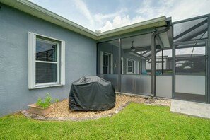 A house with a covered patio, a window with blinds, and a small garden area.