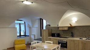 A compact kitchen with a dining area, featuring a microwave, oven, and a small sink. - Le Case Del Sole, Rustico 60sqm sea view and private garden, 2.5km from the sea (Verzi)