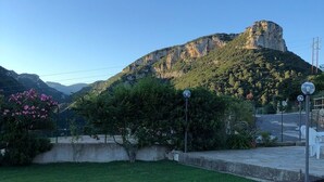 A grassy area with a mountain in the background, a fence, and some trees. - Le Case Del Sole, Rustico 60sqm sea view and private garden, 2.5km from the sea (Verzi)