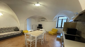 A compact living space with a dining area, sofa, and kitchenette. - Le Case Del Sole, Rustico 60sqm sea view and private garden, 2.5km from the sea (Verzi)