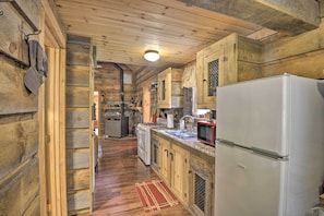 A wooden cabin interior with a kitchen area featuring a refrigerator, stove, sink, and microwave. - Constantia Cabin Escape > 2 Mi to Lake Oneida (Bernhards Bay)