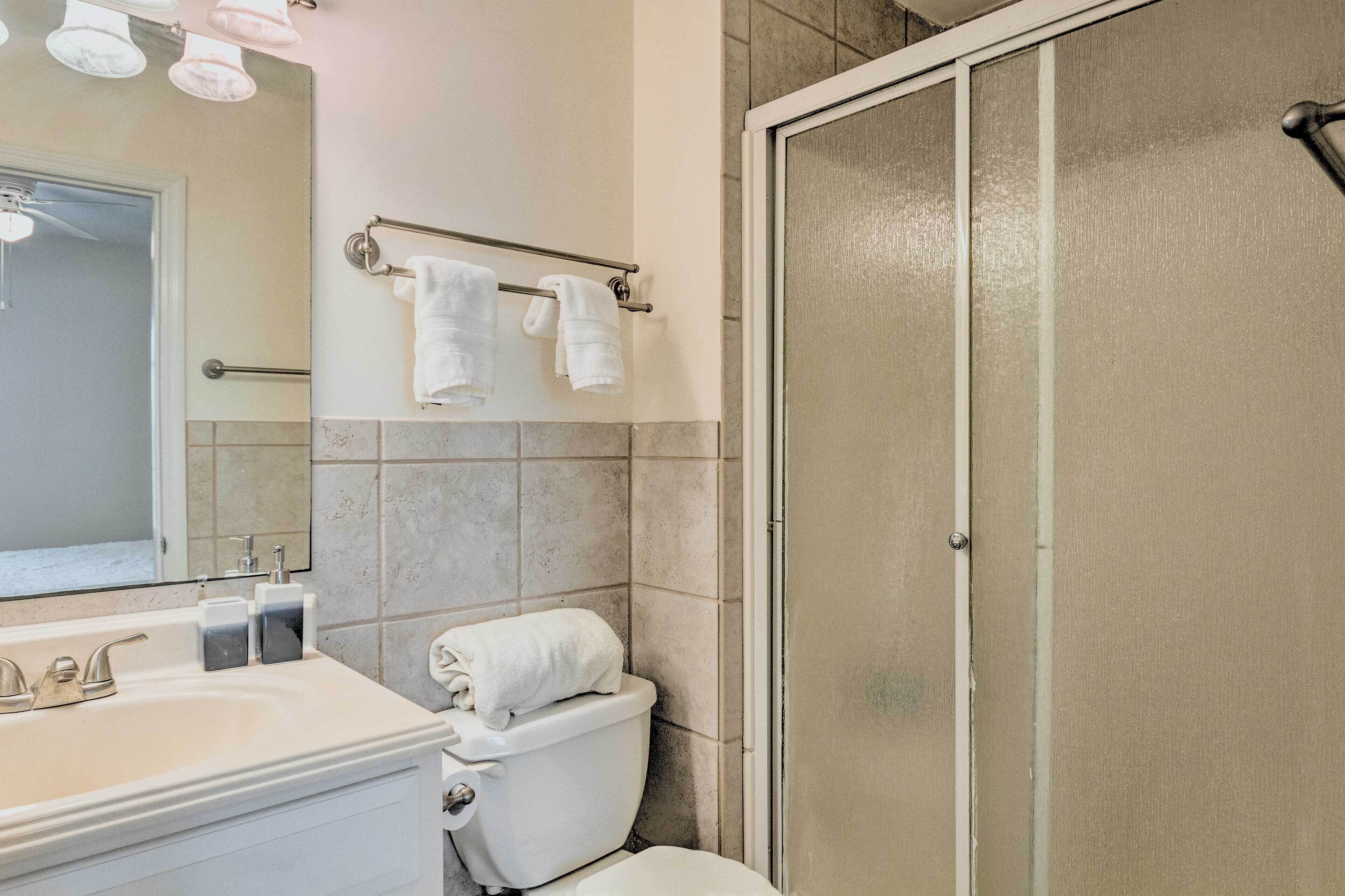 A bathroom with a sink, toilet, and a glass shower enclosure.