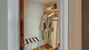 A small, narrow hallway with a wooden floor, a radiator, and a clothing rack with a robe hanging on it. - Dtwn Palm Springs Condo: Bbq, Pool, Fire Pit, Etc! (Palm Springs)