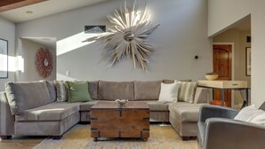 A modern living room with a sectional sofa, a decorative wall piece, and a vintage chest of drawers. - Dtwn Palm Springs Condo: Bbq, Pool, Fire Pit, Etc! (Palm Springs)
