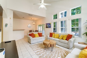 A spacious living area with two white sofas, a wooden coffee table, and a ceiling fan. - Townhome in Berkeley Lake Resort, 9 Mi to Wdw! (Kissimmee)