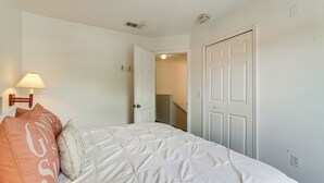 A bedroom with a bed, a nightstand, a lamp, and a door leading to a hallway. - Townhome in Berkeley Lake Resort, 9 Mi to Wdw! (Kissimmee)