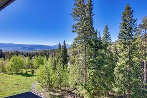 A forested area with tall pine trees and a clear view of distant mountains. - 10 Mi to Keystone Slopes: Mtn-view Condo! (Silverthorne)