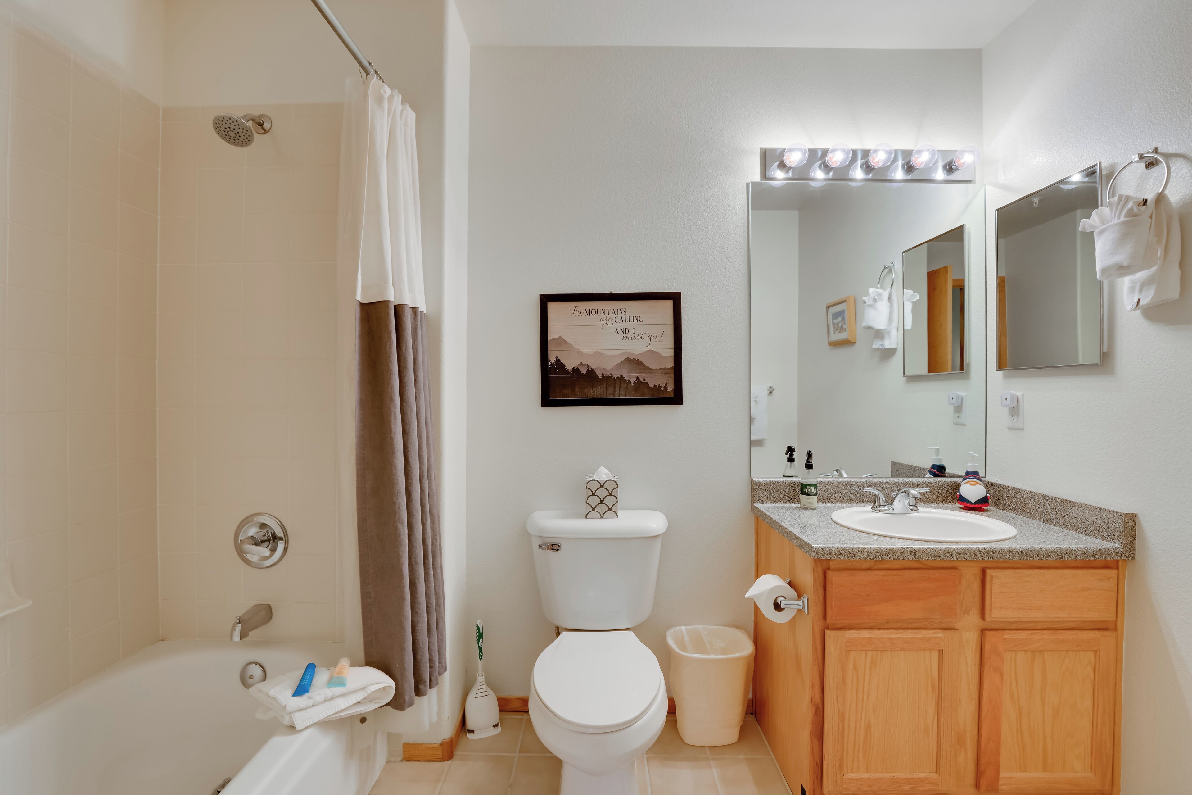 A bathroom with a bathtub, toilet, sink, and vanity.