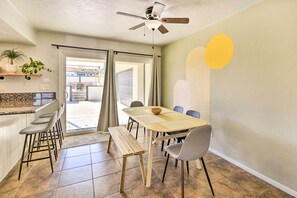 A dining area with a wooden table, chairs, a bench, and a ceiling fan. - Desert Retreat w/ Backyard Oasis & Mtn Views! (Twentynine Palms)
