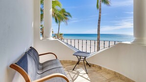 A balcony with a view of the ocean, a chair, and a small table. - Beachfront Oasis in Cabo w/ Resort Amenities! (San José del Cabo)