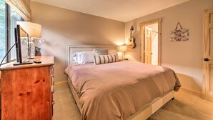 Ein Schlafzimmer mit einem Bett, einem Schminktisch, einer Lampe, einer Gitarre und einem Wandschild.