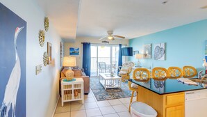 A spacious living area with a dining table, chairs, and a kitchen area with a dishwasher. - Waterfront Middle Bass Condo w/ Pool Access! (Put-in-Bay)