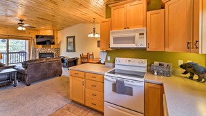 A wooden-paneled kitchen with a microwave, oven, and wooden cabinets.