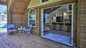 A wooden cabin with a covered porch, a kitchen area, and a bar with stools. - Floating Home on Columbia River w/ Provided Kayaks (Vancouver)